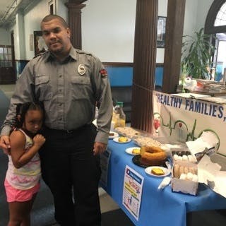 Adult and child standing next to a table with food