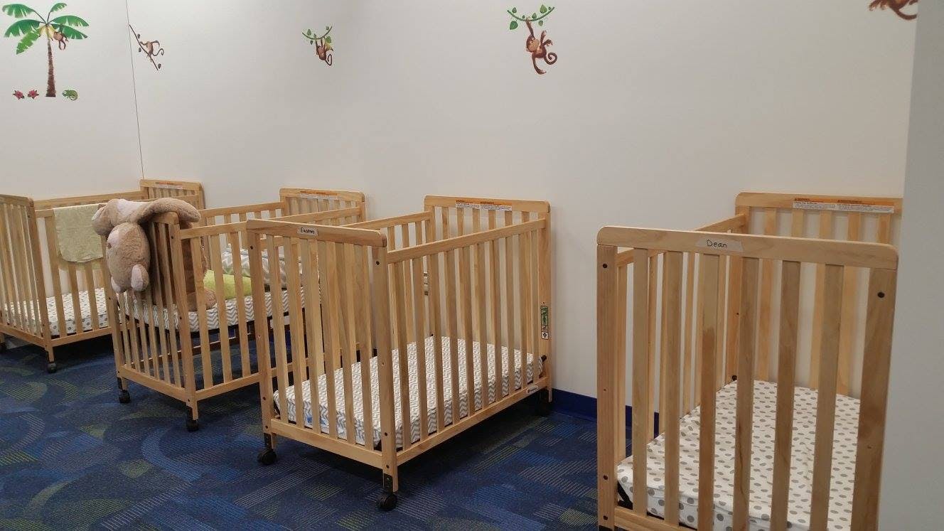 Multiple empty wooden cribs in a room