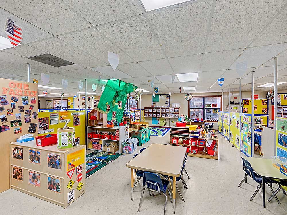 Colorful classroom with tables, chairs, and learning materials