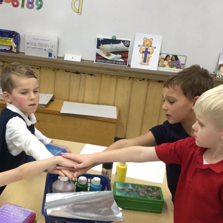 Three children with hands stacked together