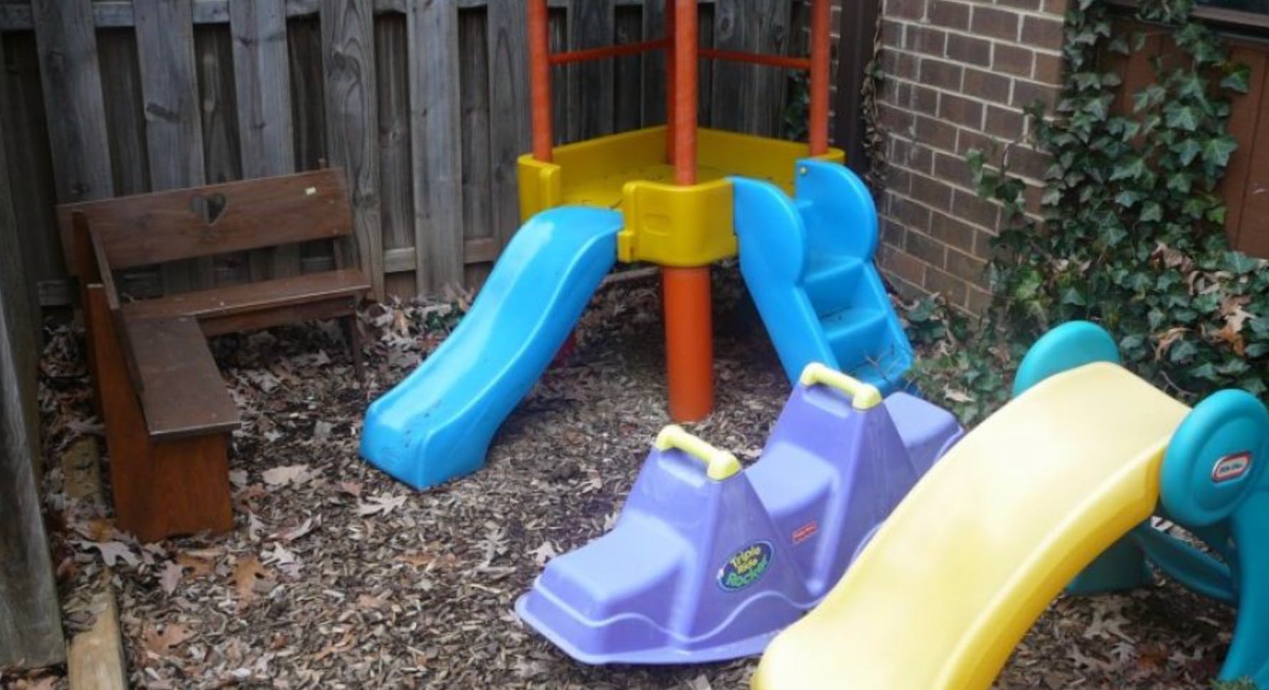 Playground with slides, a rocker, and a wooden bench