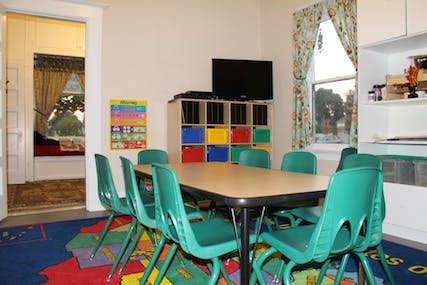 Classroom with small table and green chairs