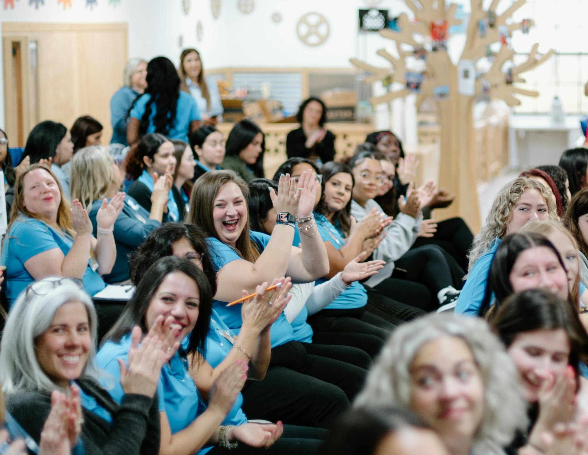 Group of people clapping in an audience