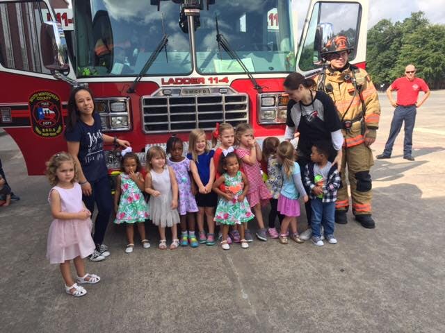 Adults and children standing in front of a fire truck