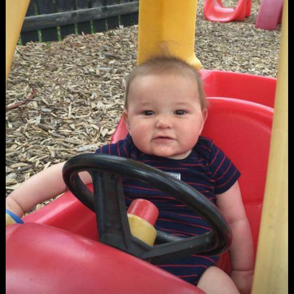 Child in a red toy car