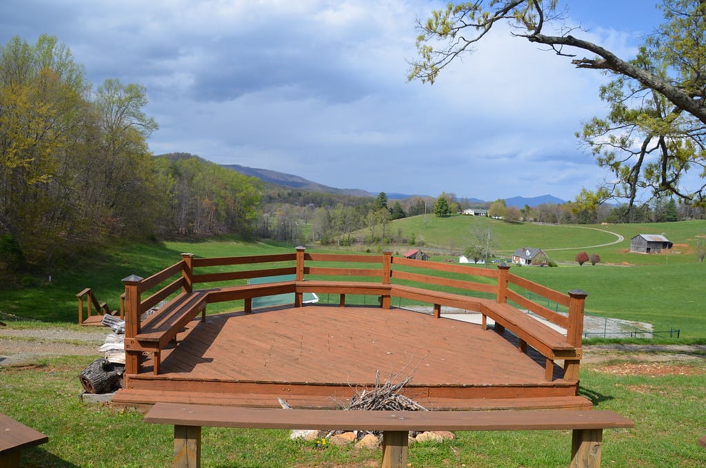 Wooden deck with benches overlooking a rural landscape with hills and fields