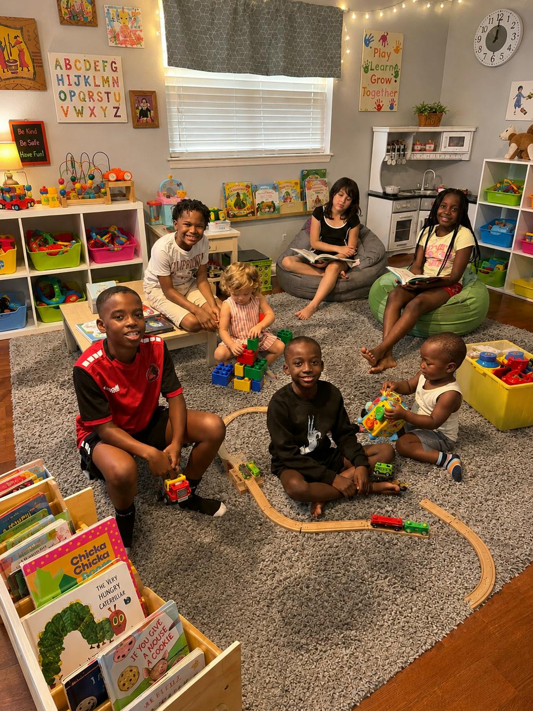Group of children playing with toys and reading books in a playroom