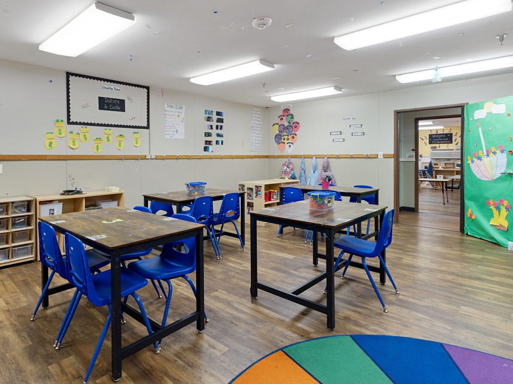 Empty classroom with small tables and blue chairs