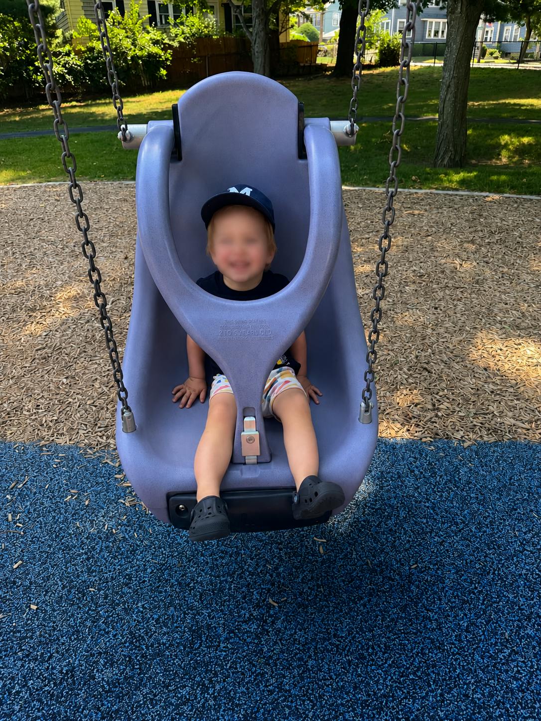 Child sitting in a bucket swing at a playground