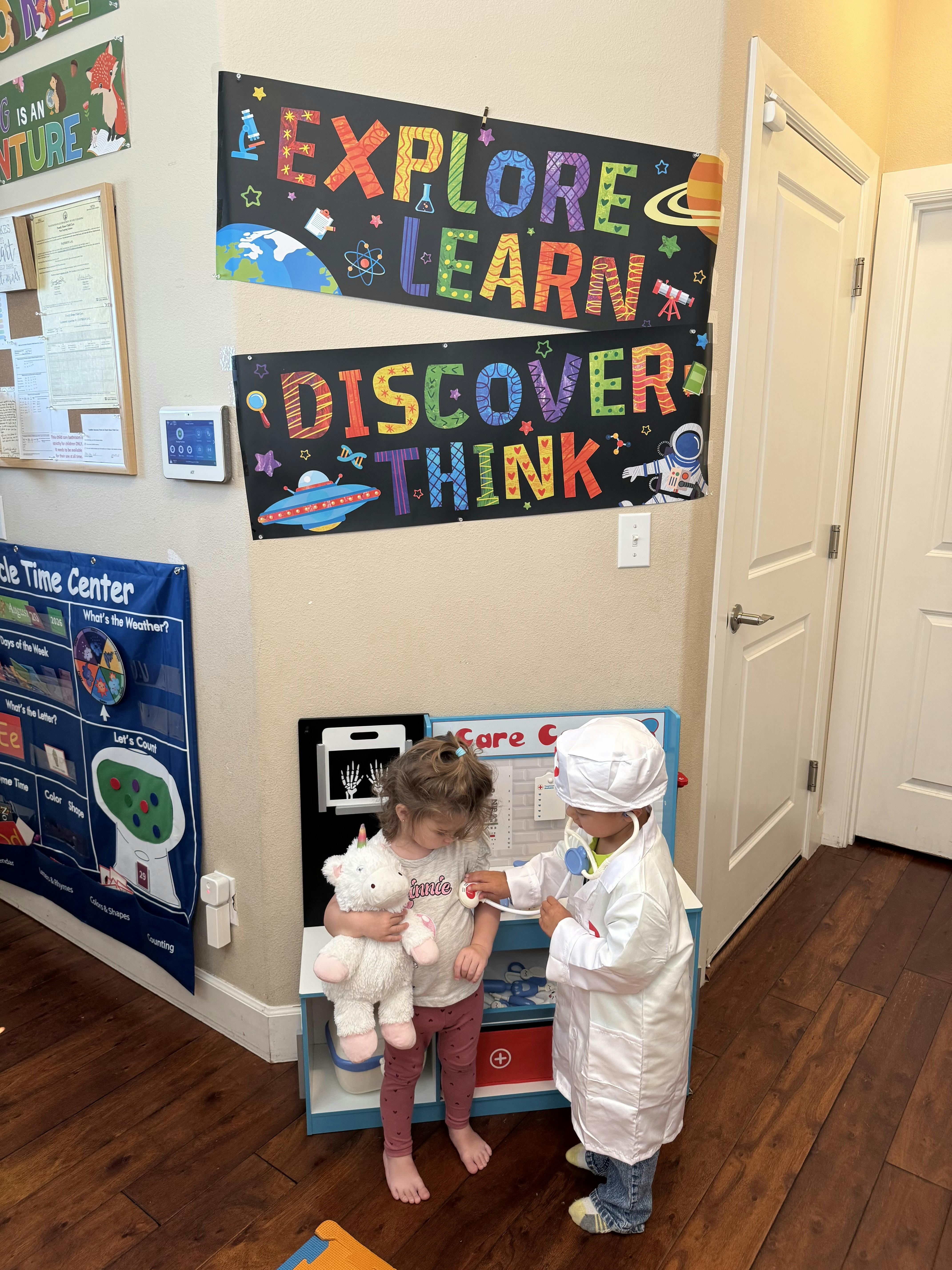 Child in doctor coat examining a plush toy with a toy stethoscope