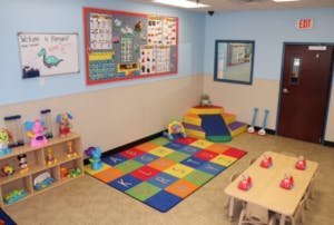 Playroom with colorful rug, toys, and small table