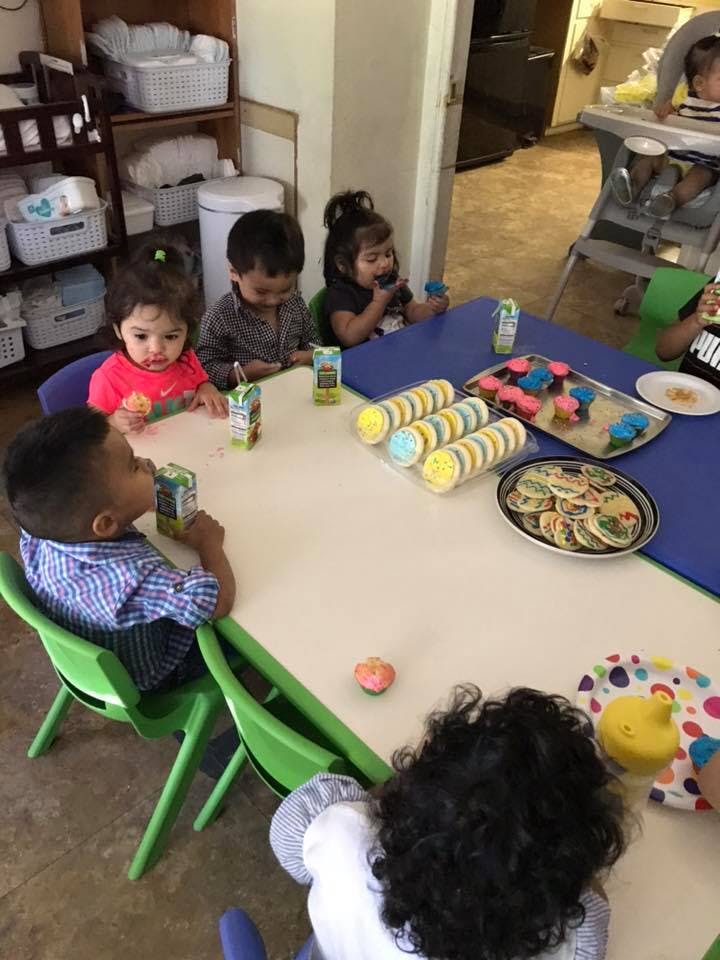 Children sitting at a table with snacks and drinks