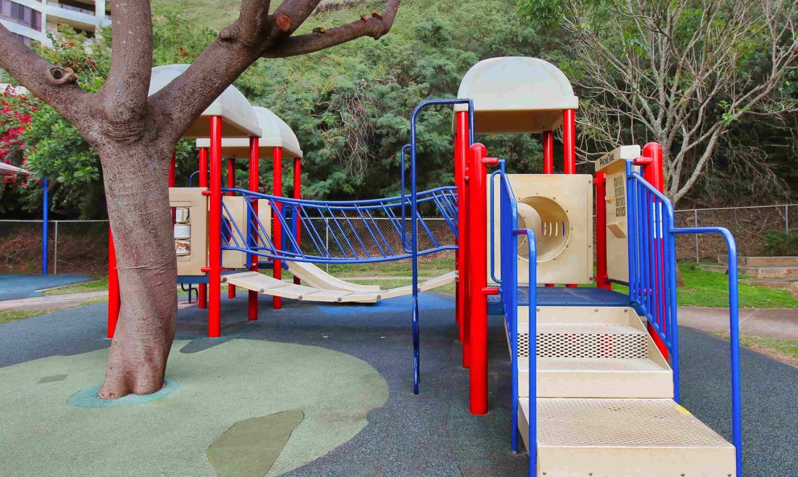 Playground with red and blue climbing structure and slides