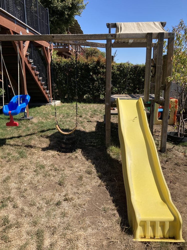 Playground with a yellow slide and two swings