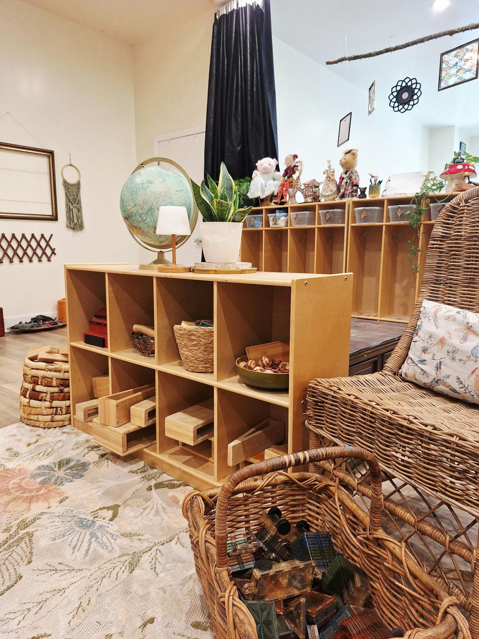 Wooden shelving unit with toys and decor in a room with a wicker chair