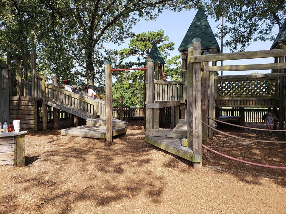 Wooden playground structure with slides and platforms