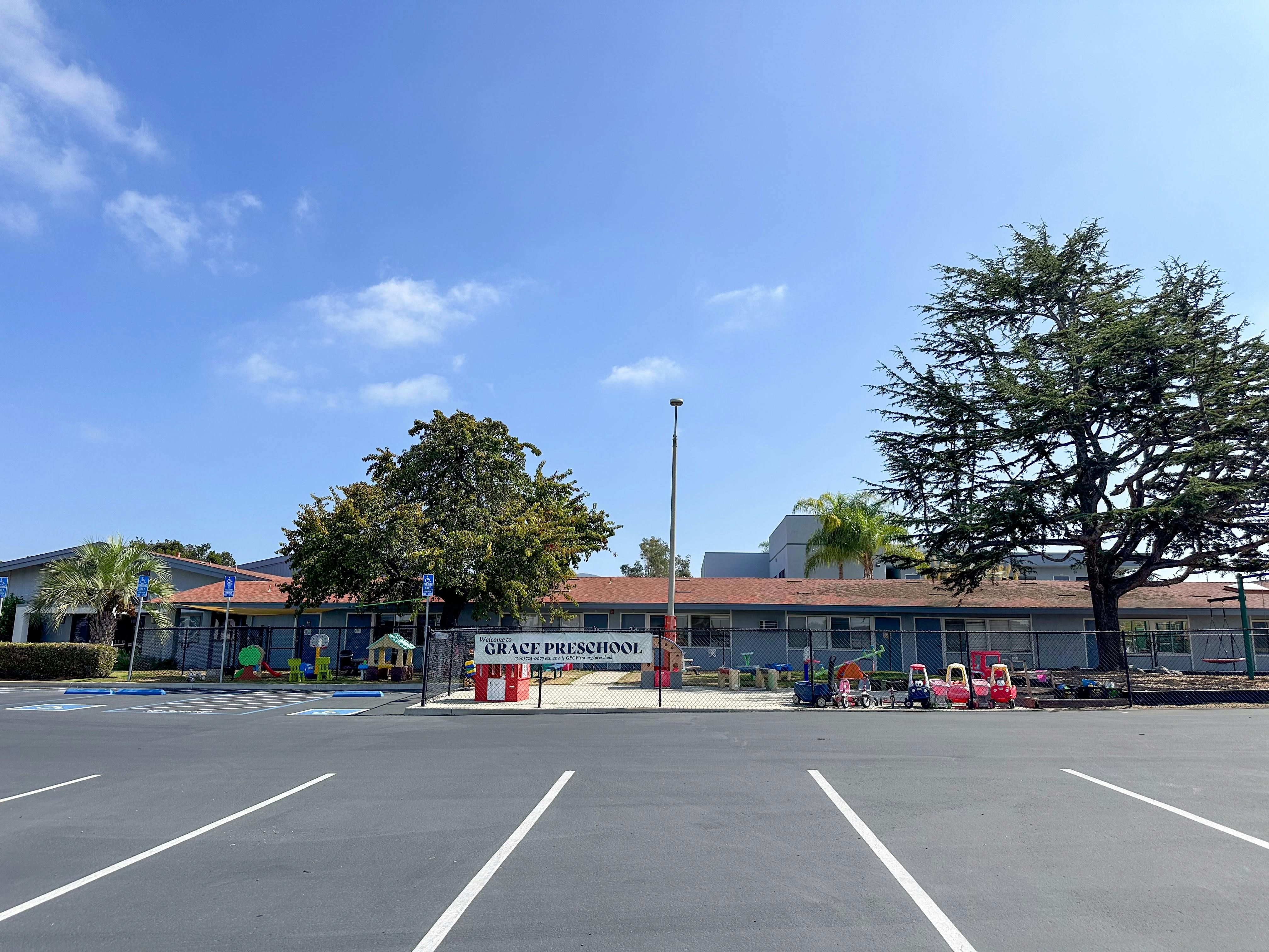 Grace Preschool building with playground equipment and parking lot