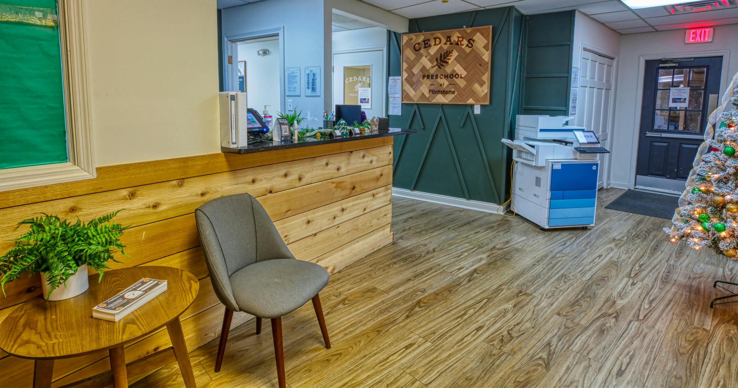 Reception desk with a wooden sign that says Cedars Preschool