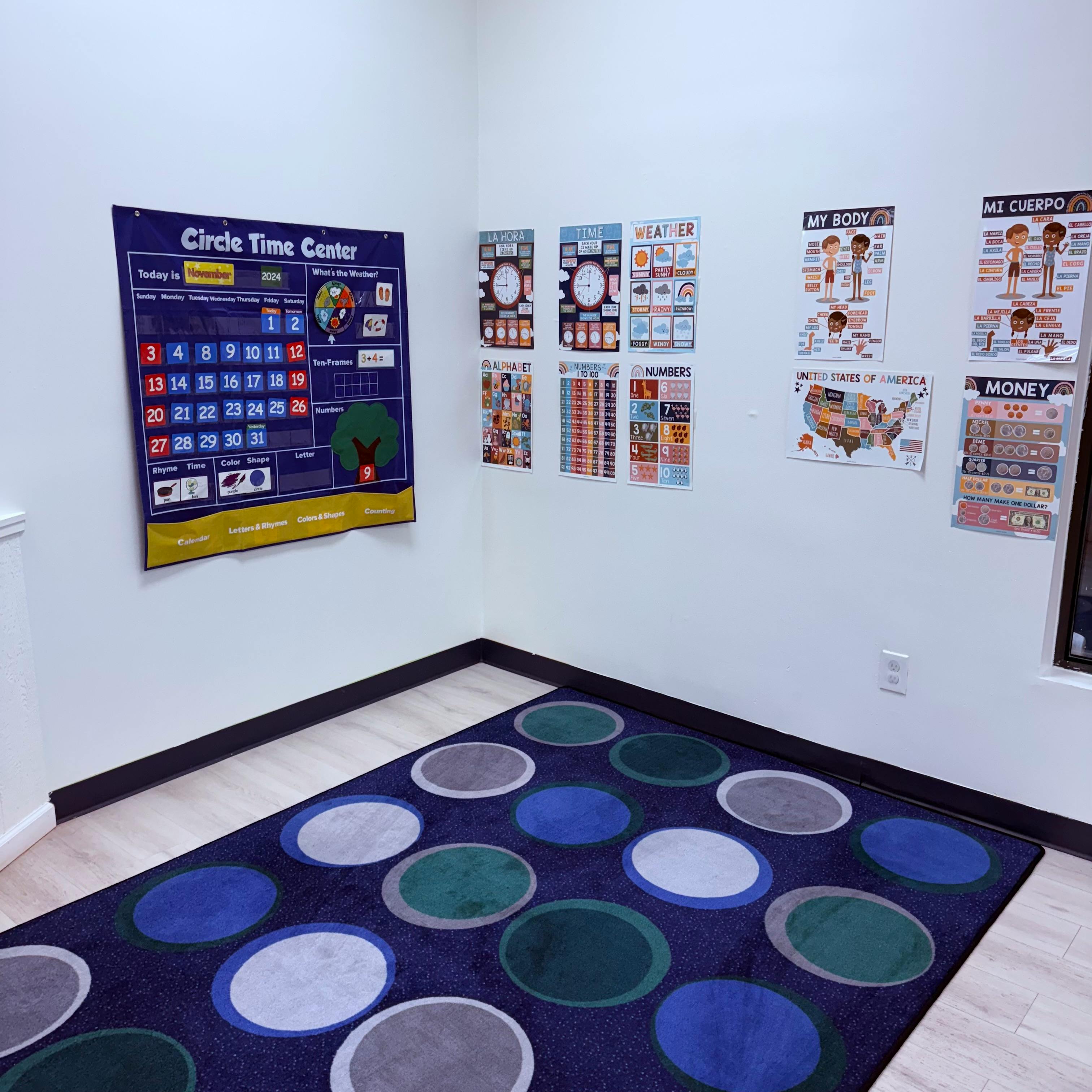 Classroom corner with a calendar poster and a rug with colorful circles