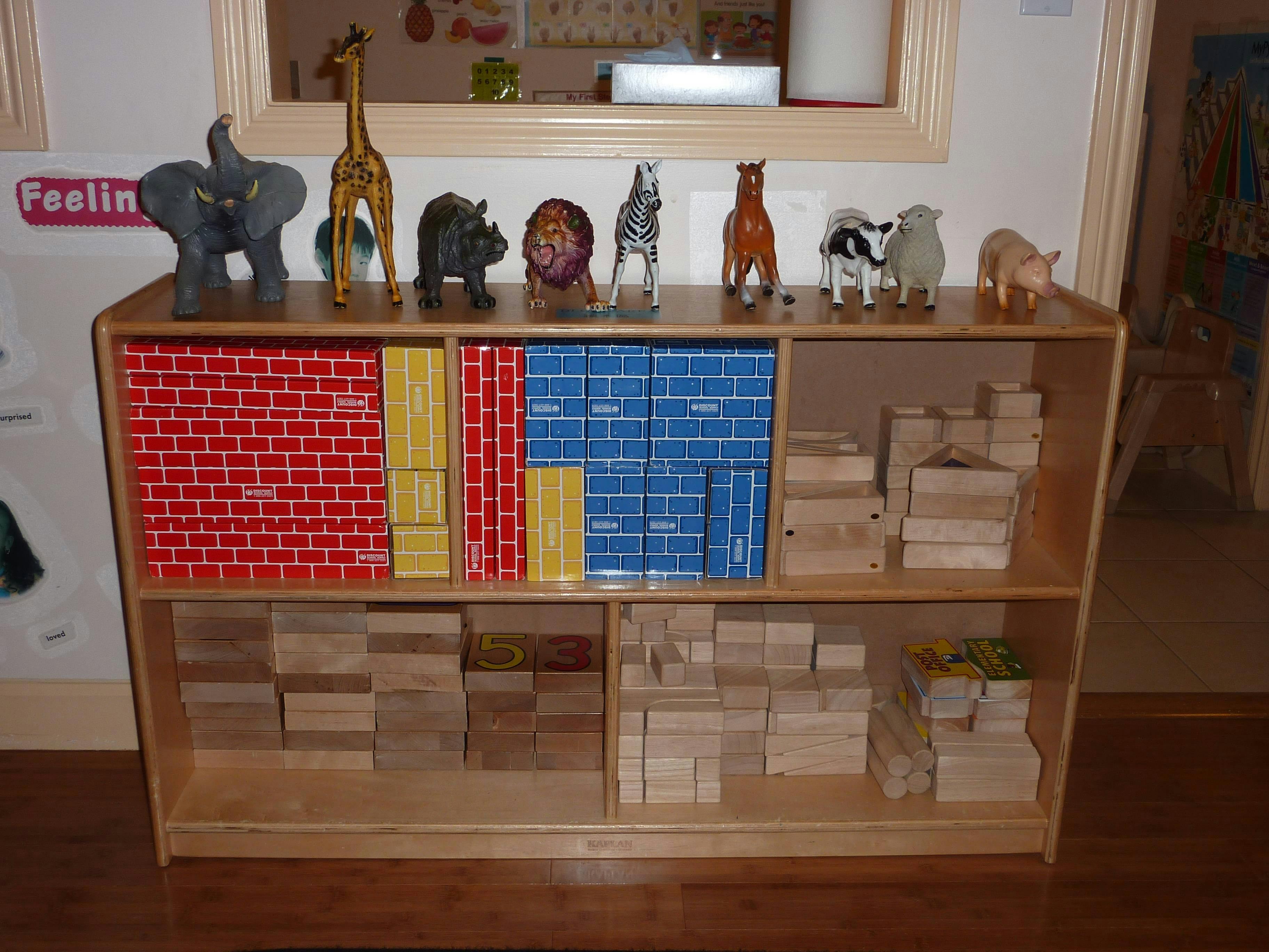 Wooden shelf with animal figurines, colorful blocks, and wooden blocks