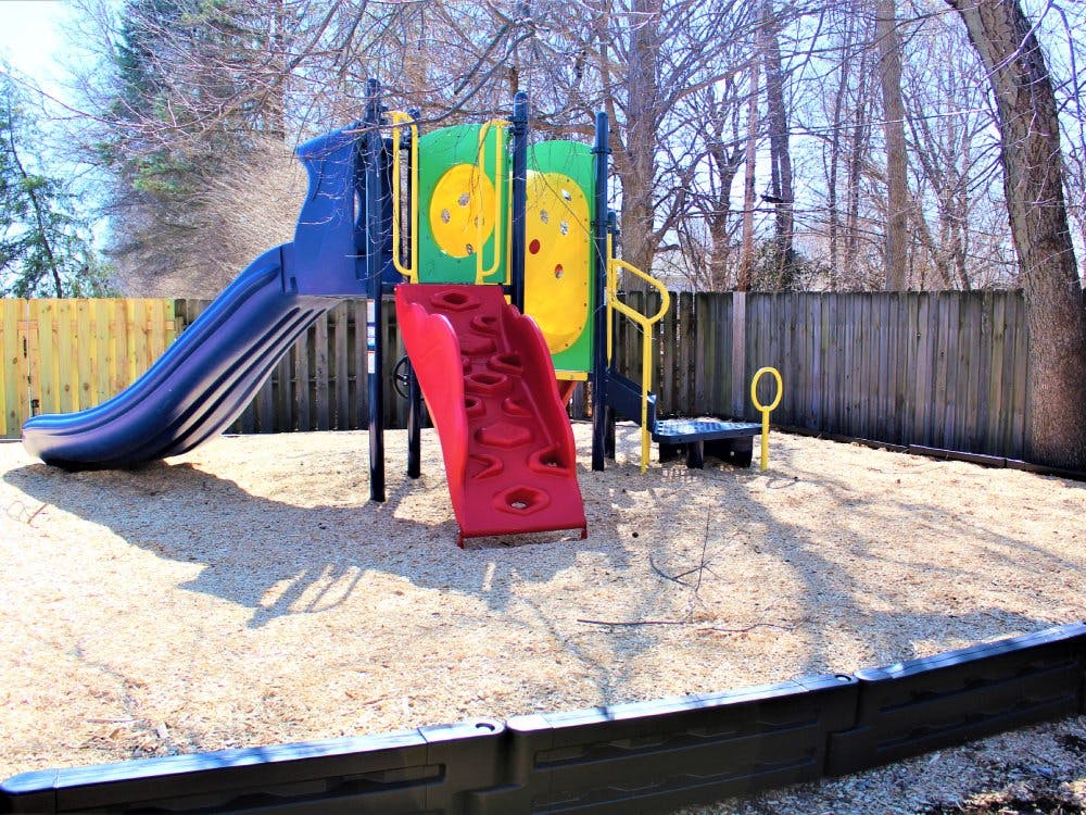 Empty playground with blue and red slides on wood chips