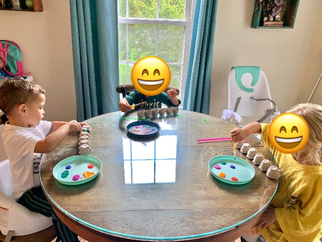 Three children at a table with craft supplies