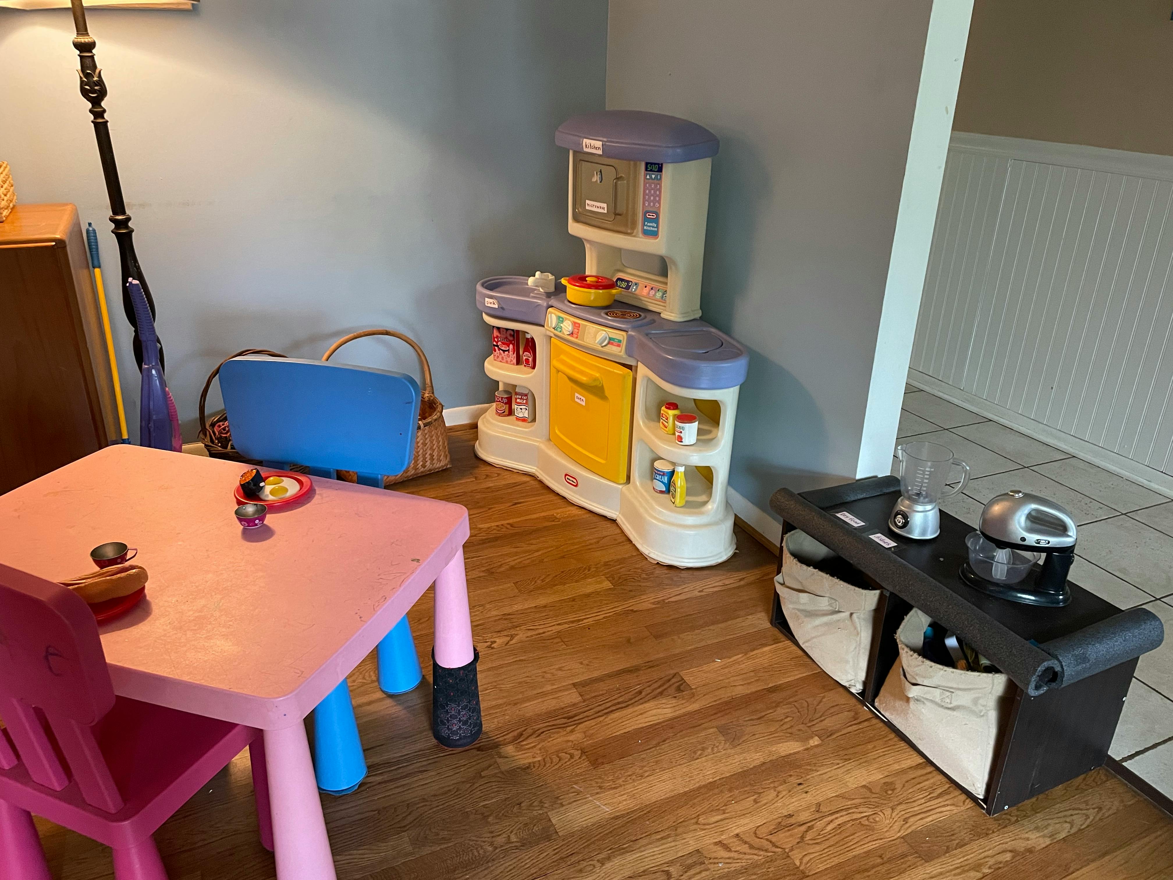 Children's play kitchen and pink table with chairs