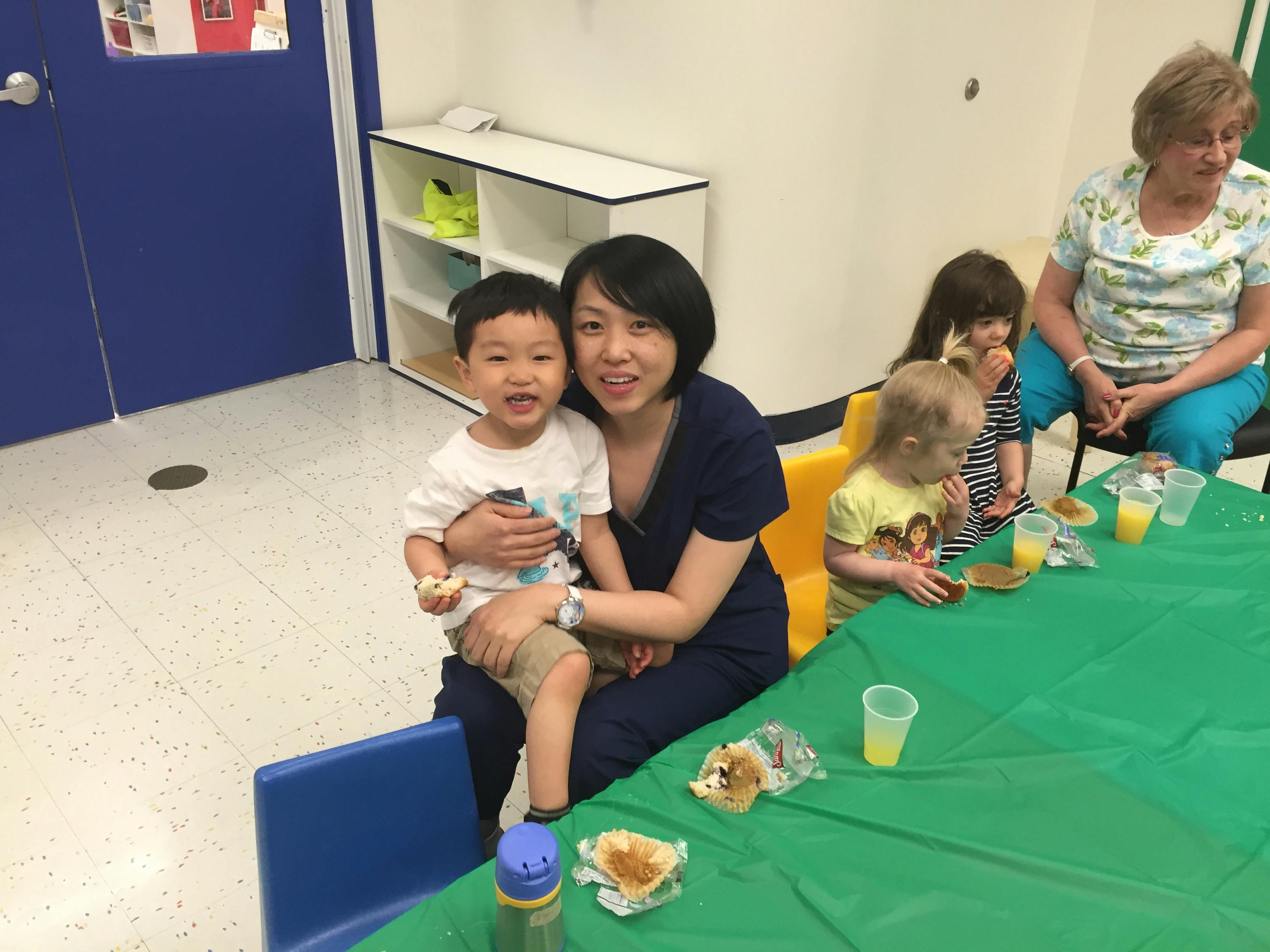 Person holding a child on their lap at a table with other people