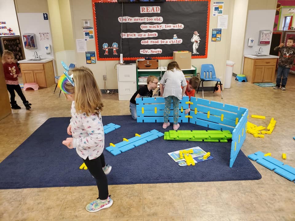 Children playing with large building blocks in a classroom
