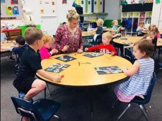 Adult and children at a table in a classroom