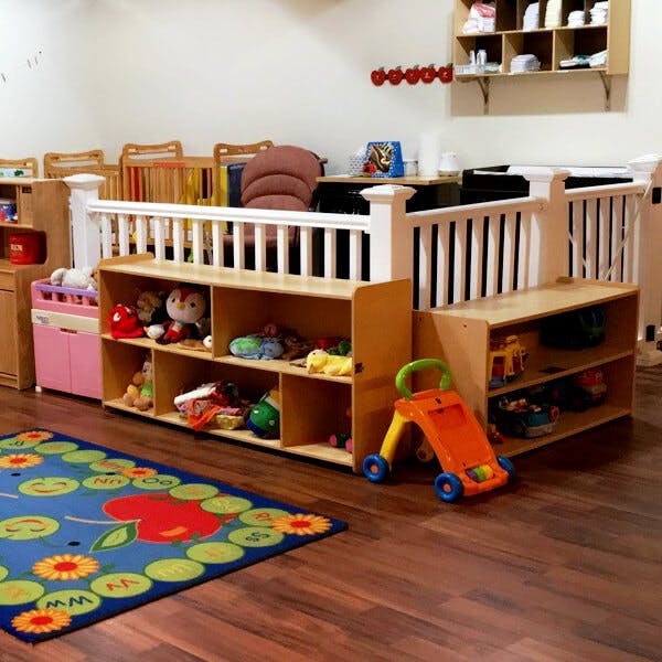 Playroom with toy shelves, a blue rug, and a baby walker