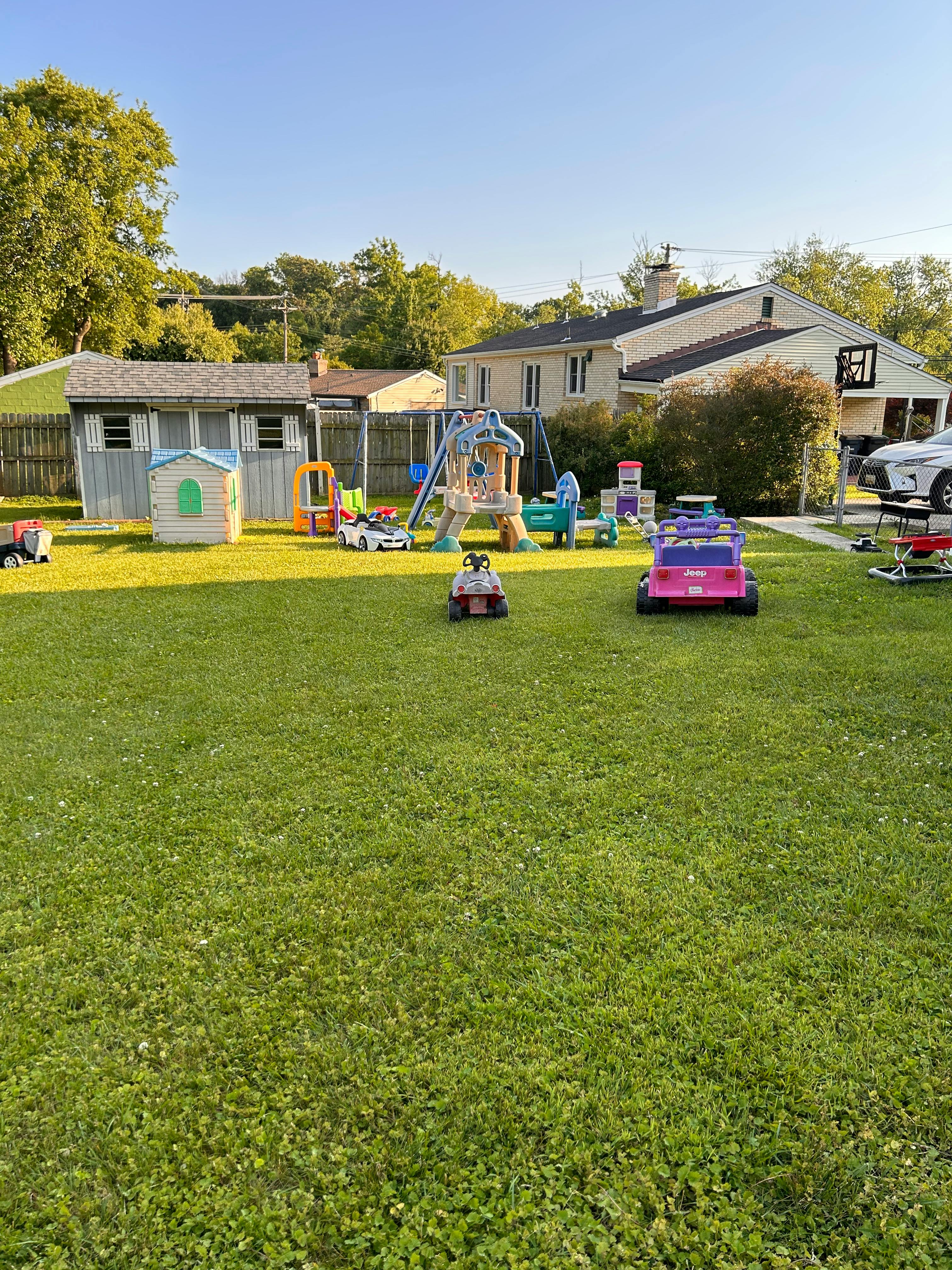 Backyard with playground equipment and ride-on toys