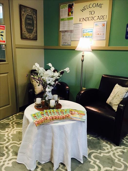 Lounge area with two chairs, a round table with brochures, and a bulletin board