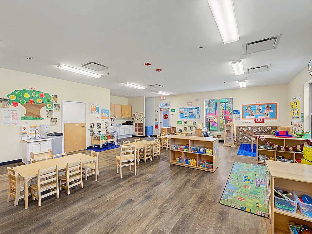 Empty colorful preschool classroom with small tables and chairs