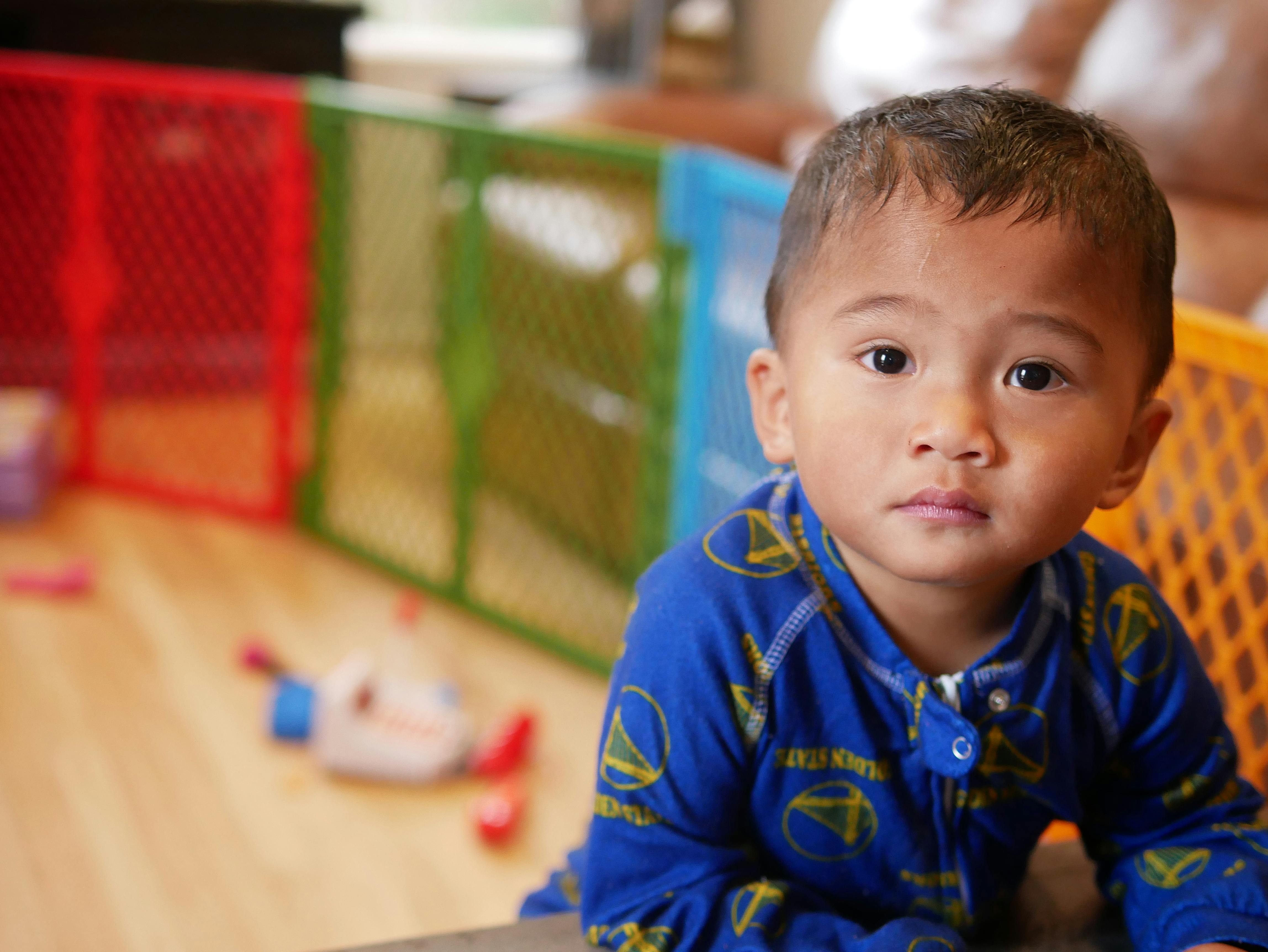 Child in blue pajamas looking forward