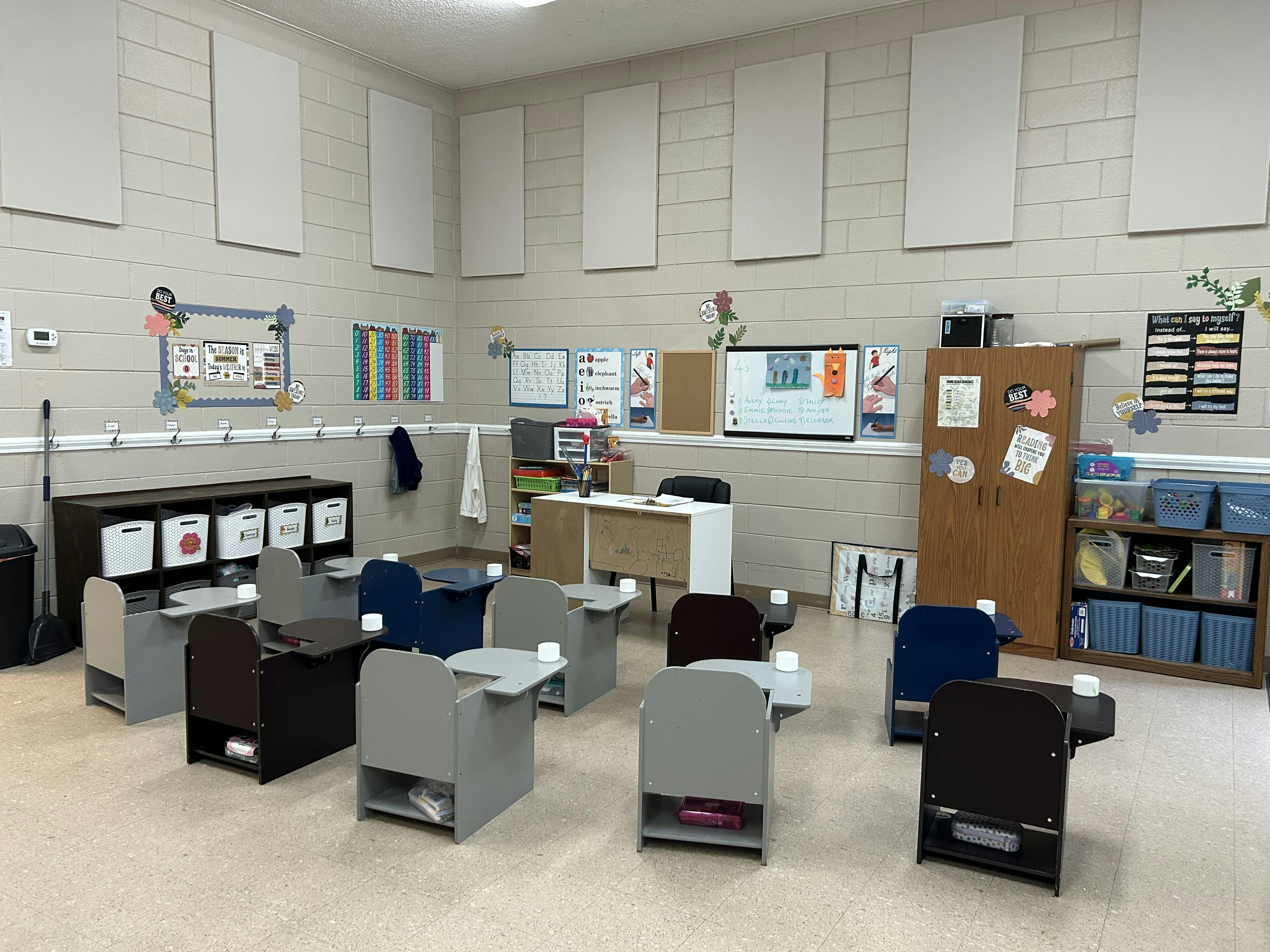 Empty classroom with small individual desks arranged in rows
