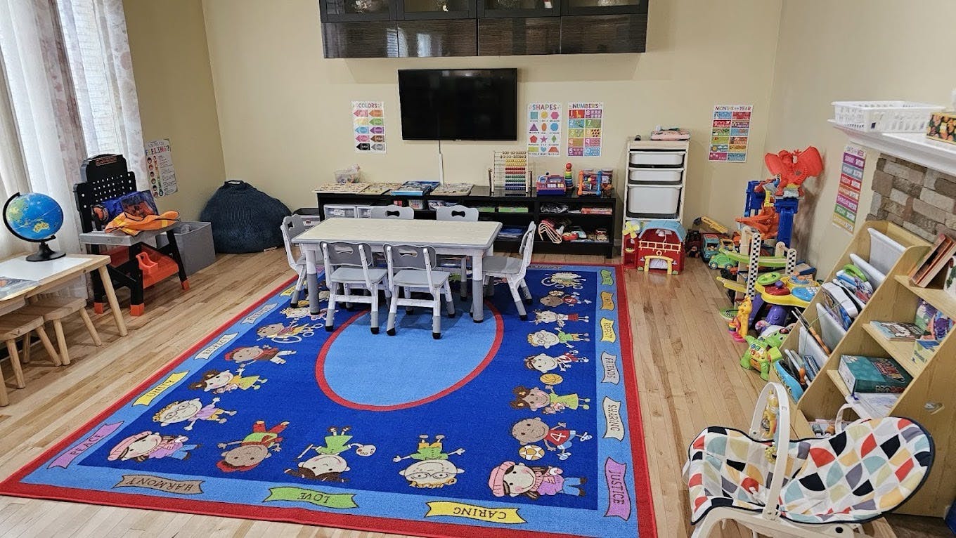 Children's classroom or playroom with small tables, chairs, and learning posters