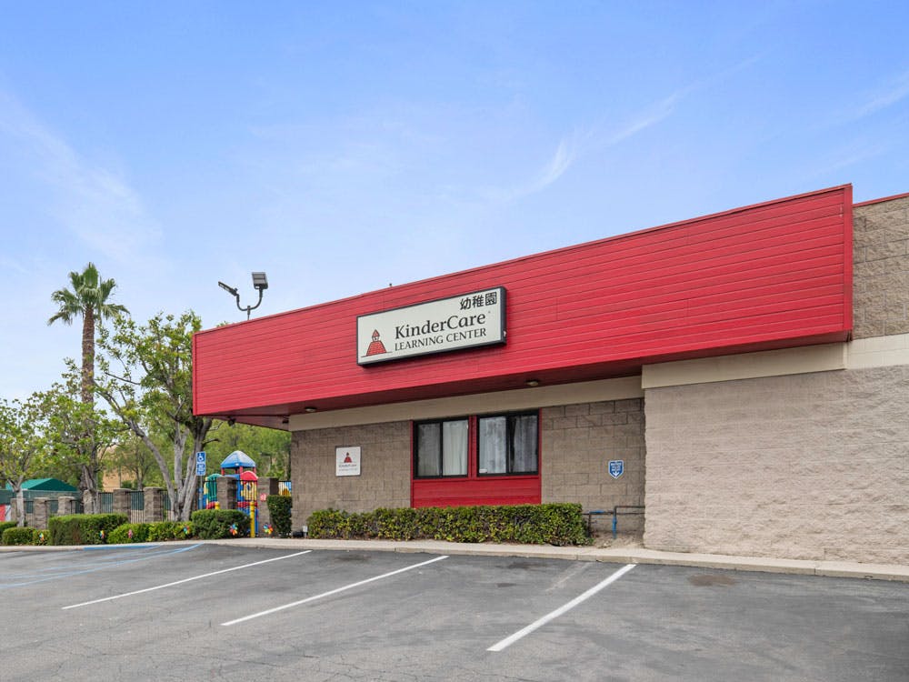 KinderCare Learning Center building with red facade and a playground