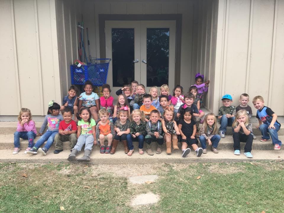 Group of children sitting on steps outdoors