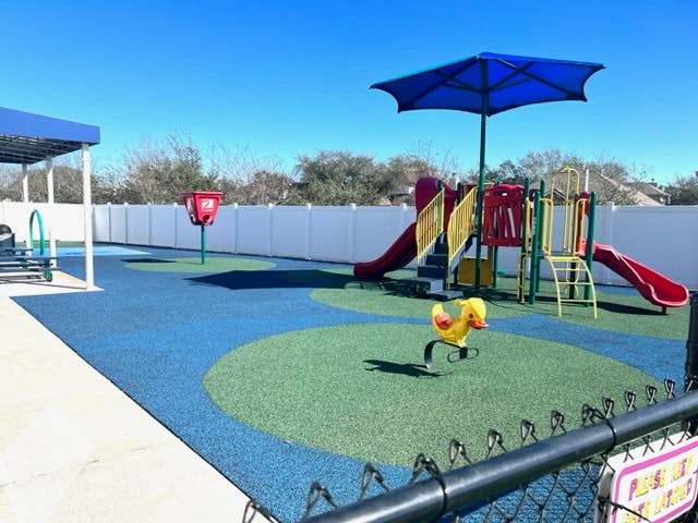 Outdoor playground with slides, climbing structures, and a spring rider