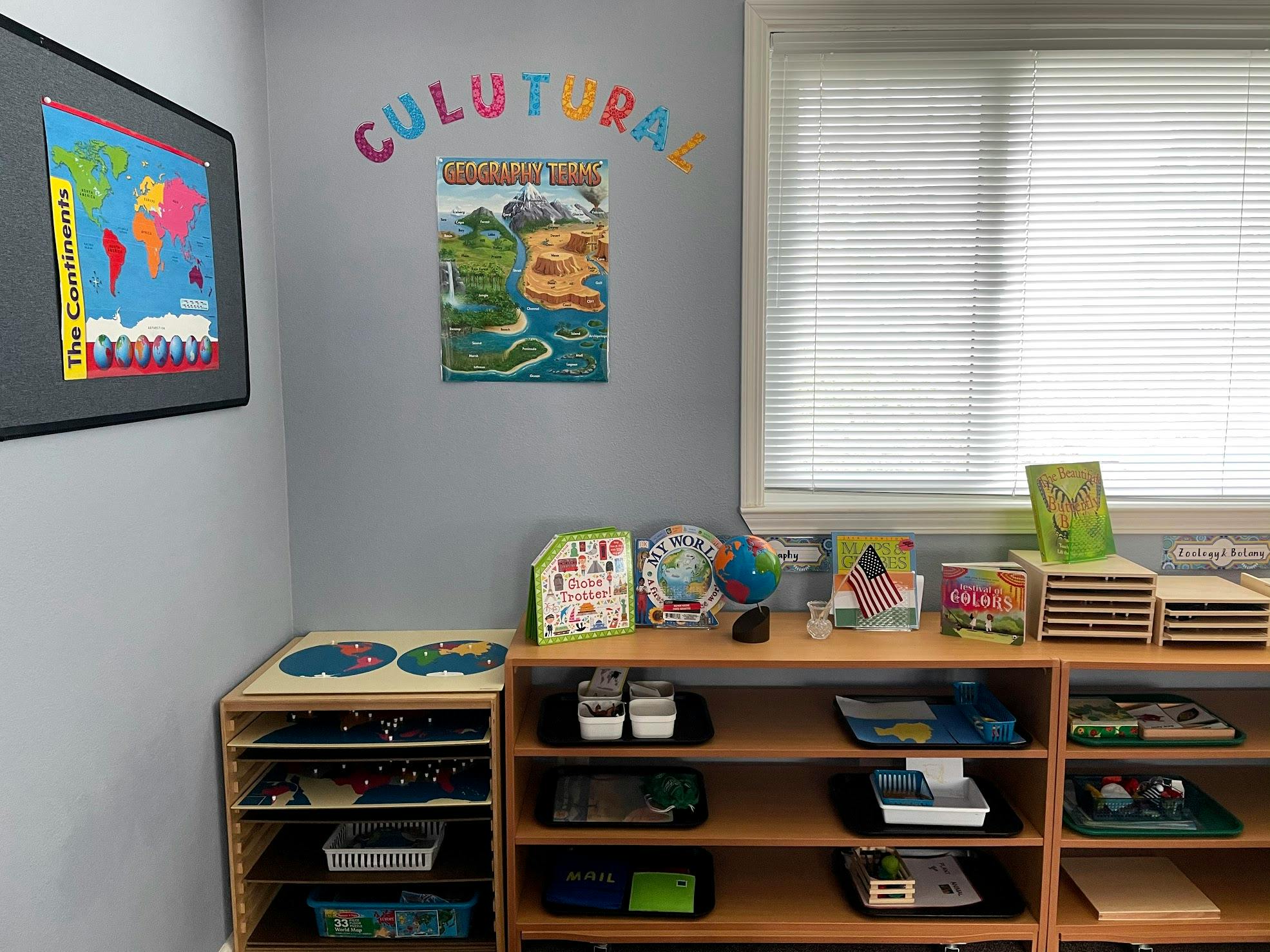 Classroom corner with shelves of learning materials, maps, and a window