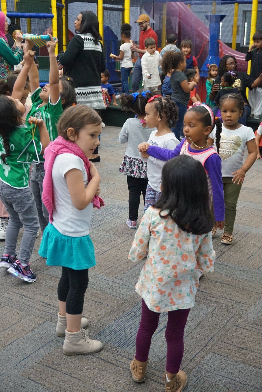 Children playing indoors with adults supervising