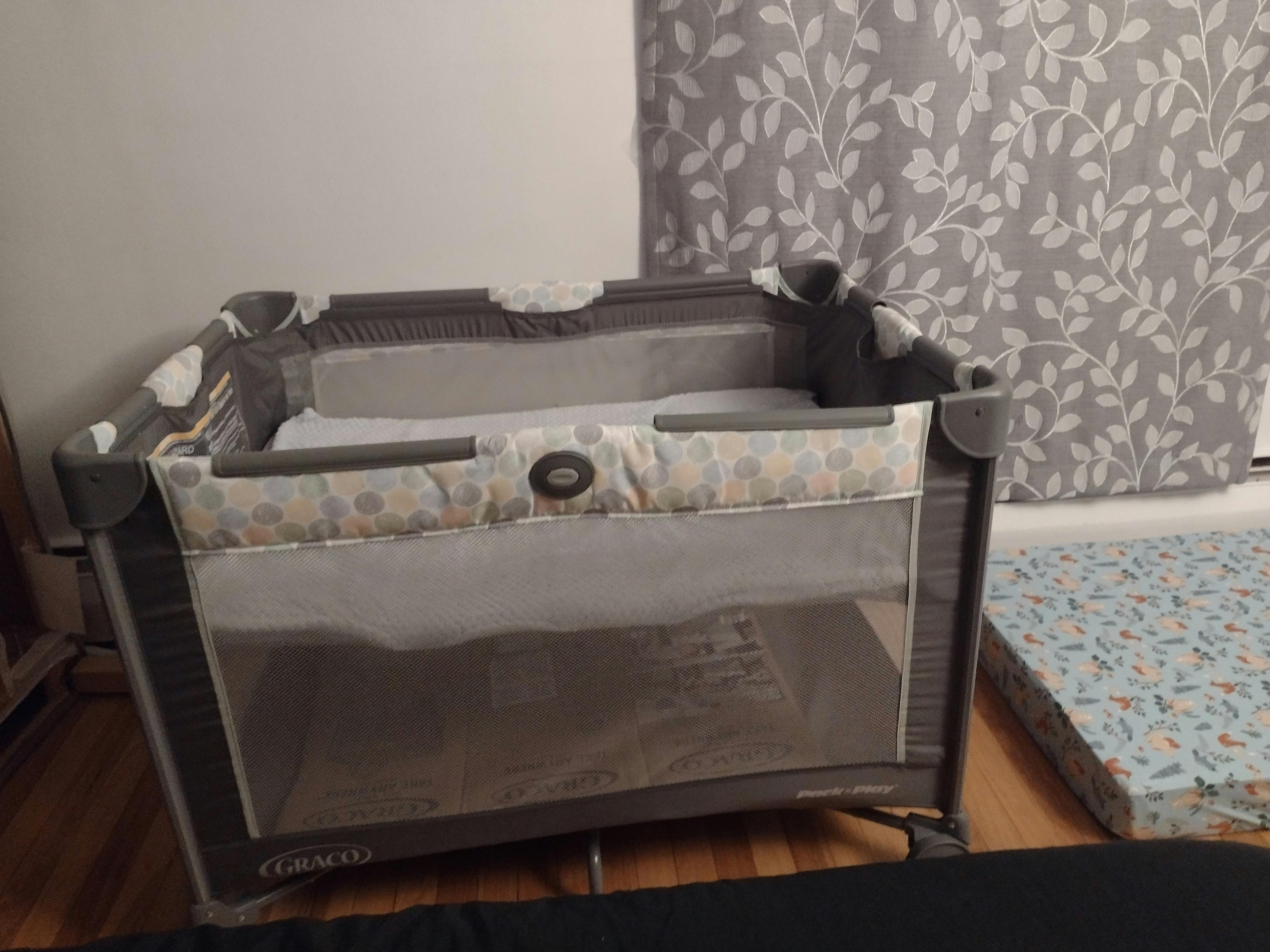 Portable playard with mesh sides and a patterned top rail