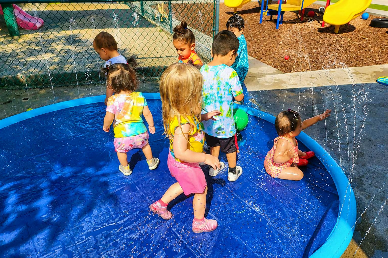 Group of children playing in a water sprinkler pad