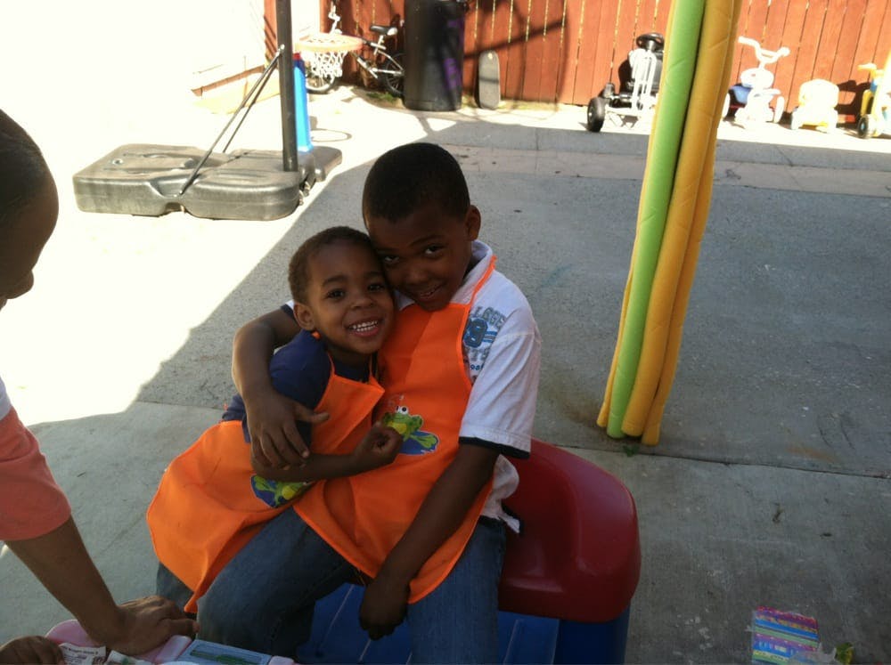 Two children in orange aprons embracing