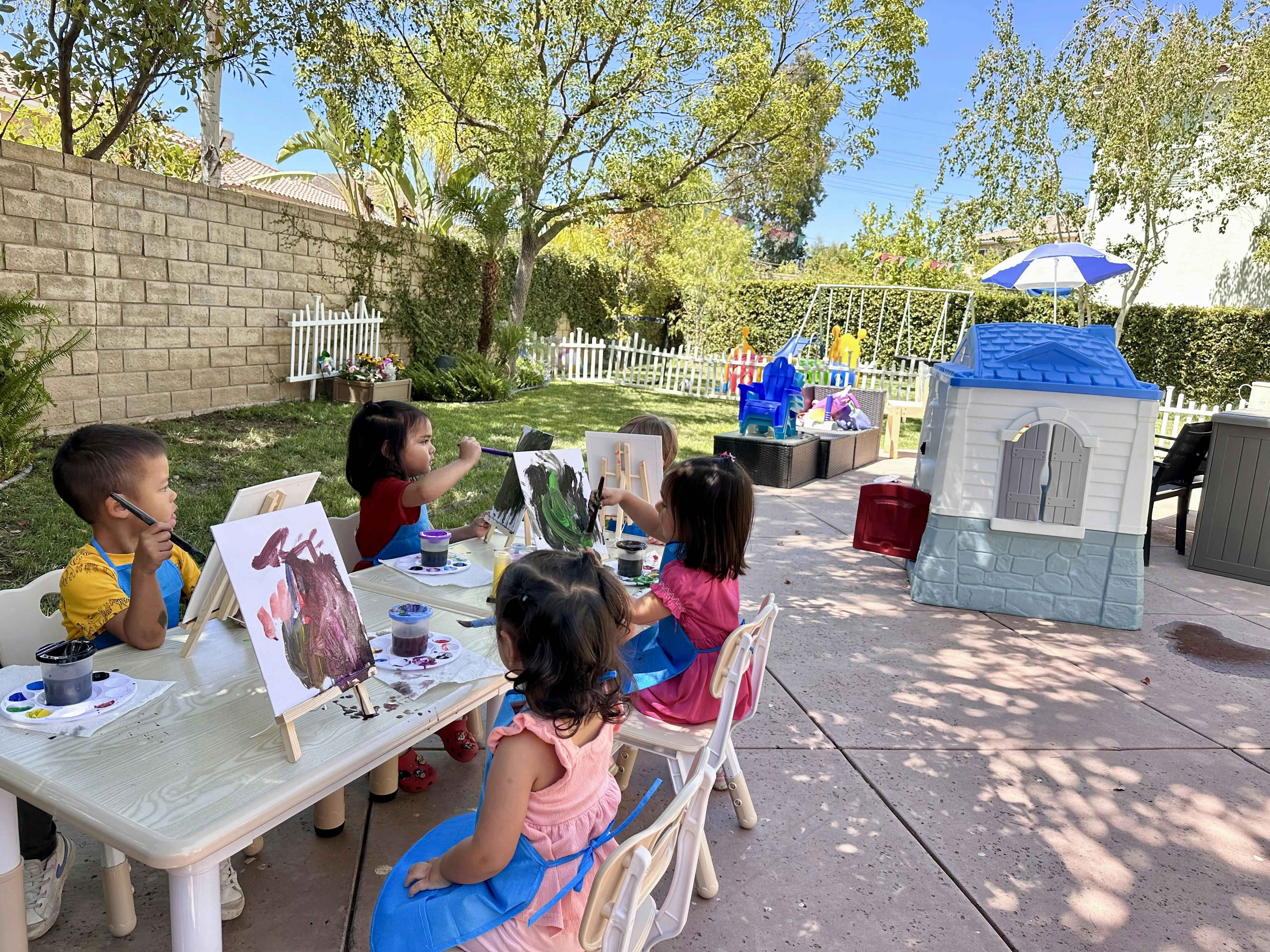 Children painting at easels outdoors