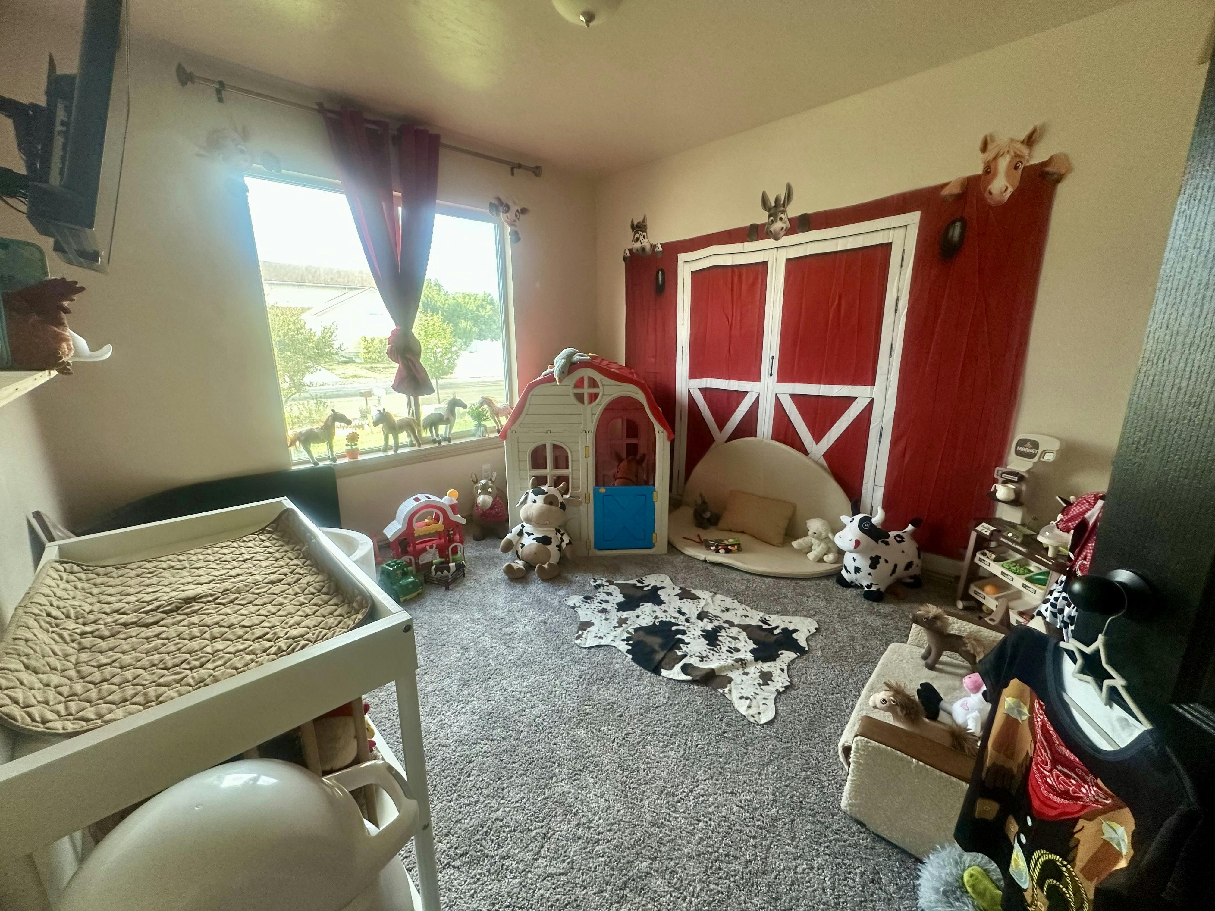 Child's room with a red barn wall decoration and playhouse