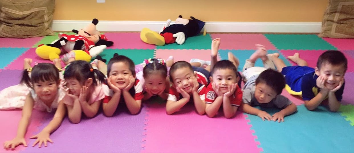 Group of children lying on their stomachs on a colorful mat