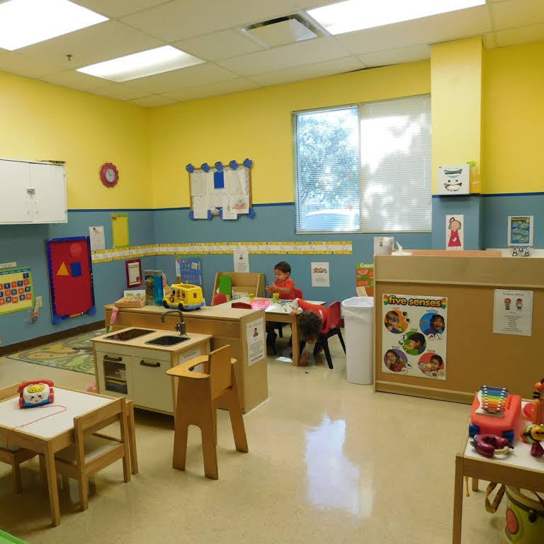 Child sitting at a table in a classroom