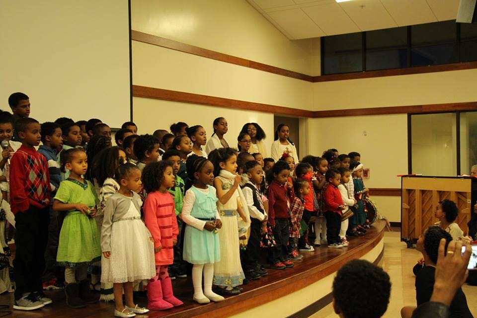 Group of children and adults standing on a stage